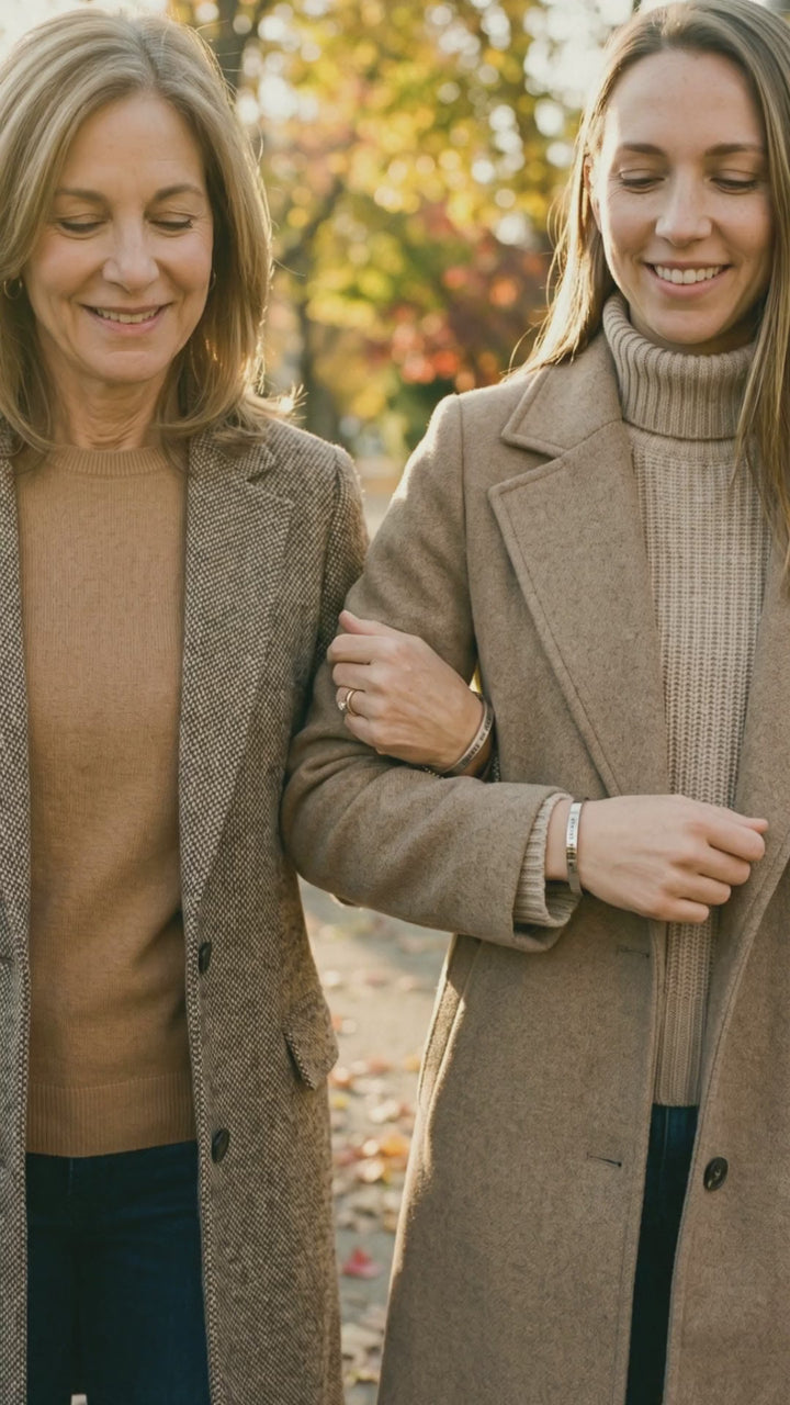 Video: a mom and daughter walk arm in arm wearing matching cuffs