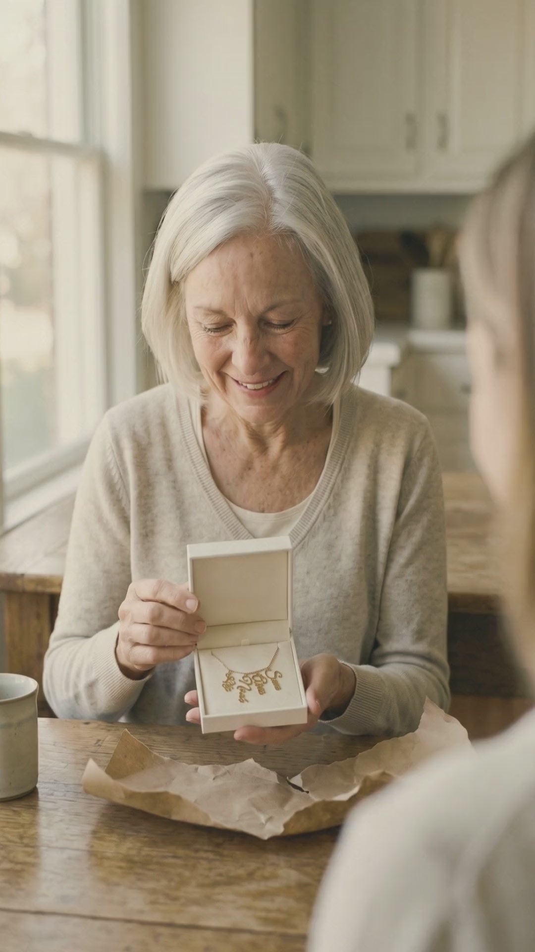 Video: a grandmother opens her grandkids' names necklace and quietly rests a hand over her heart