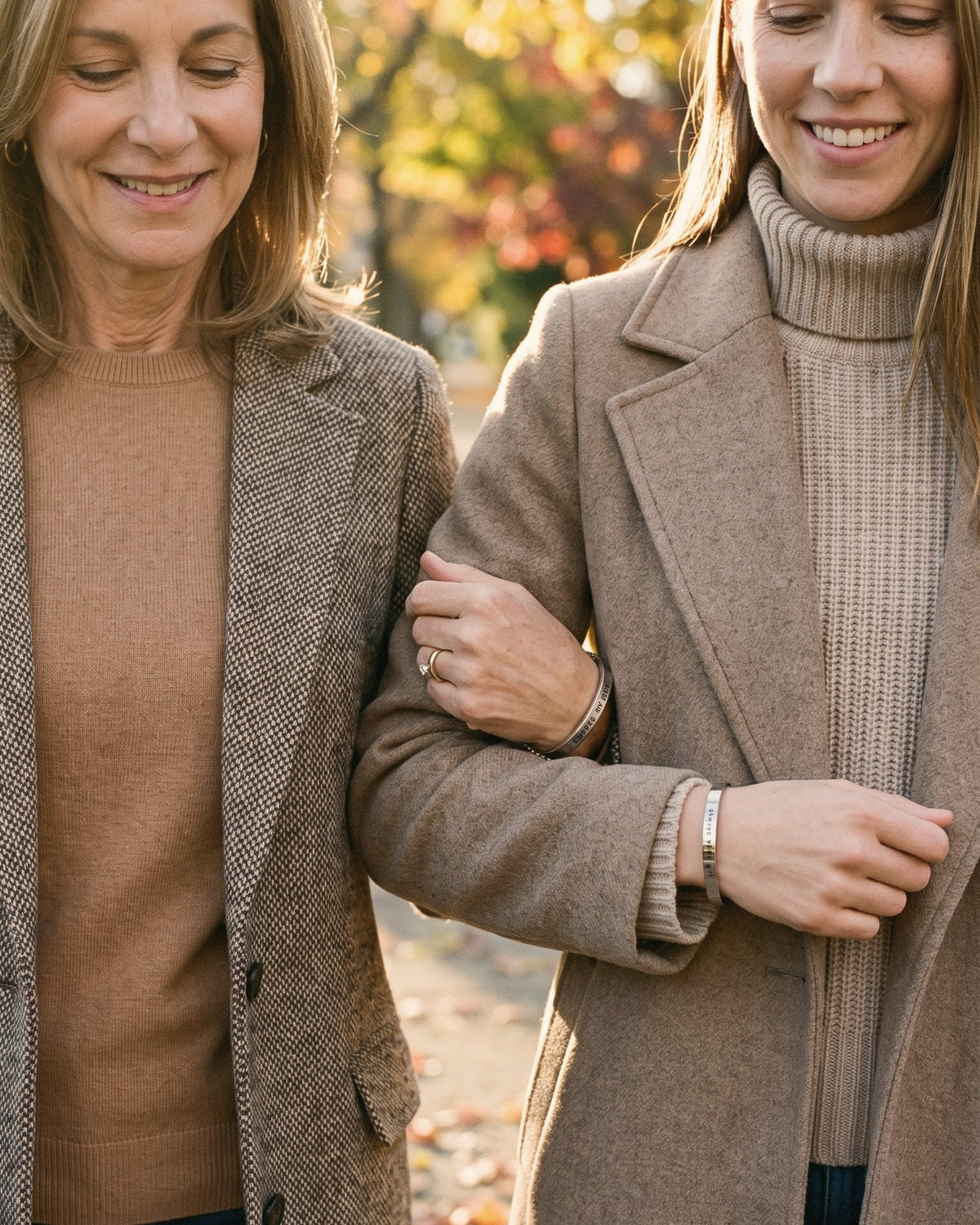 A mom and her grown daughter walking arm in arm, wearing matching cuffs