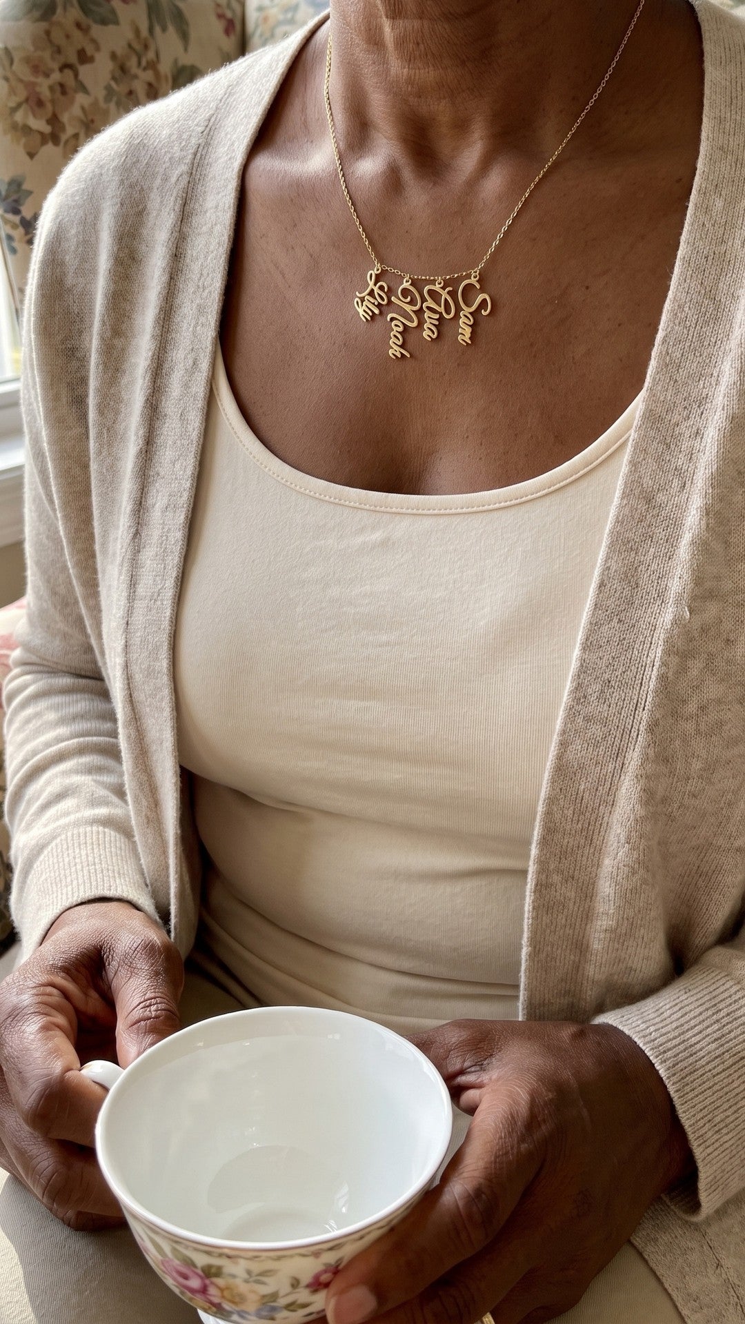 Grandma necklace with grandkids names, worn at home with a cup of tea