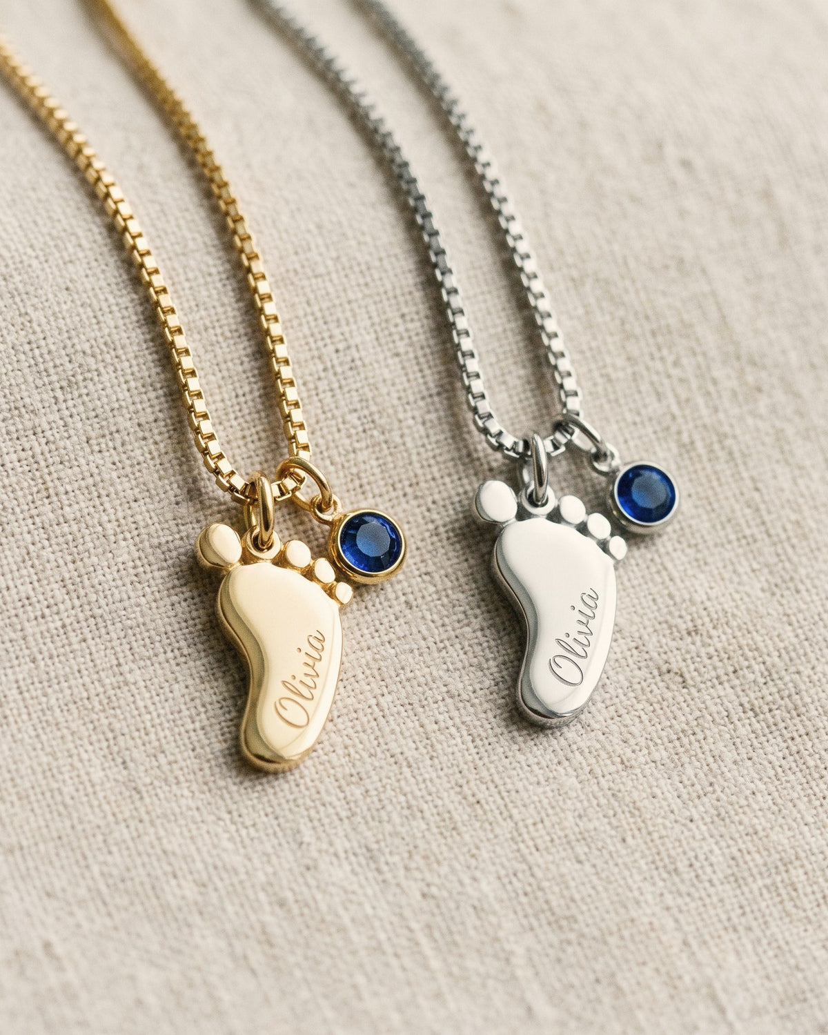 One baby-feet charm in 18K gold plating and one in polished stainless steel