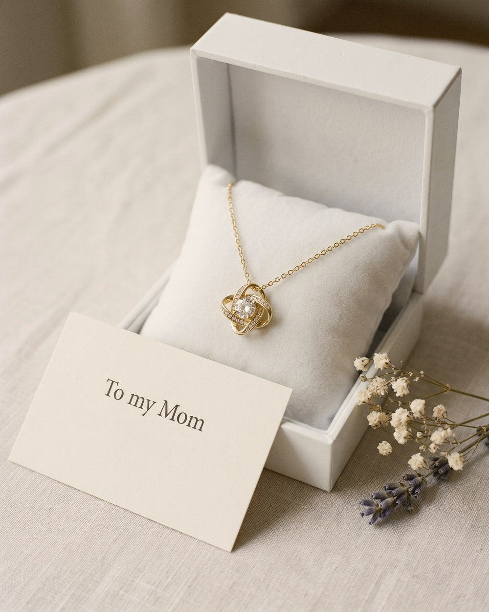 The love knot necklace in its gift box with the printed To my Mom card