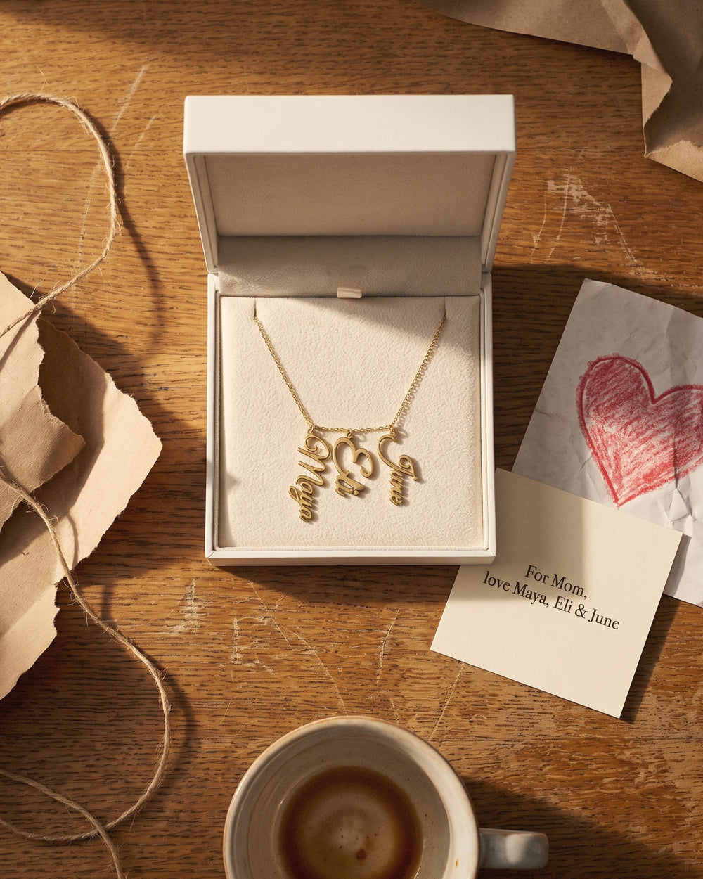The kids' names necklace in its gift box with a printed card