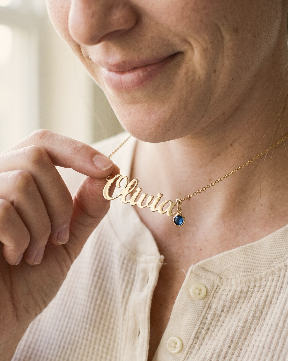 Close-up of the gold name Olivia with the birthstone hanging at the end